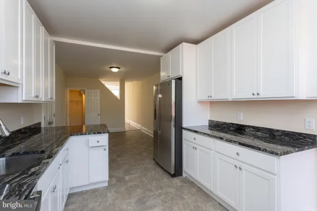 a kitchen with granite countertop white cabinets and stainless steel appliances