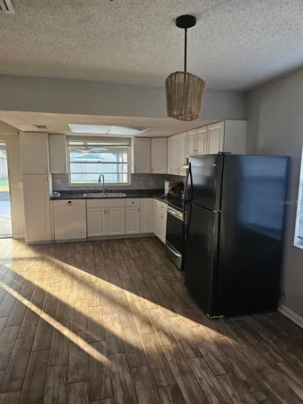a kitchen with granite countertop a refrigerator and a sink
