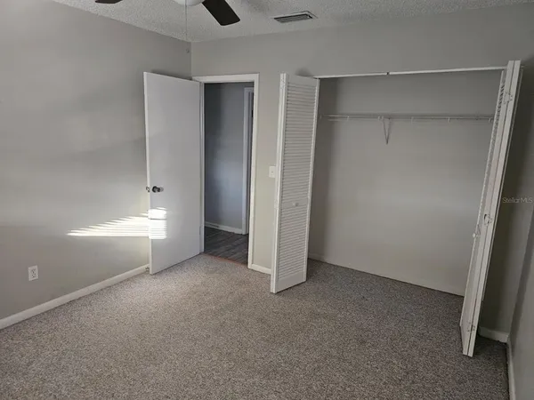 an empty room with closet and windows