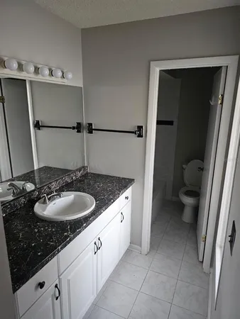 a bathroom with a granite countertop sink and a mirror