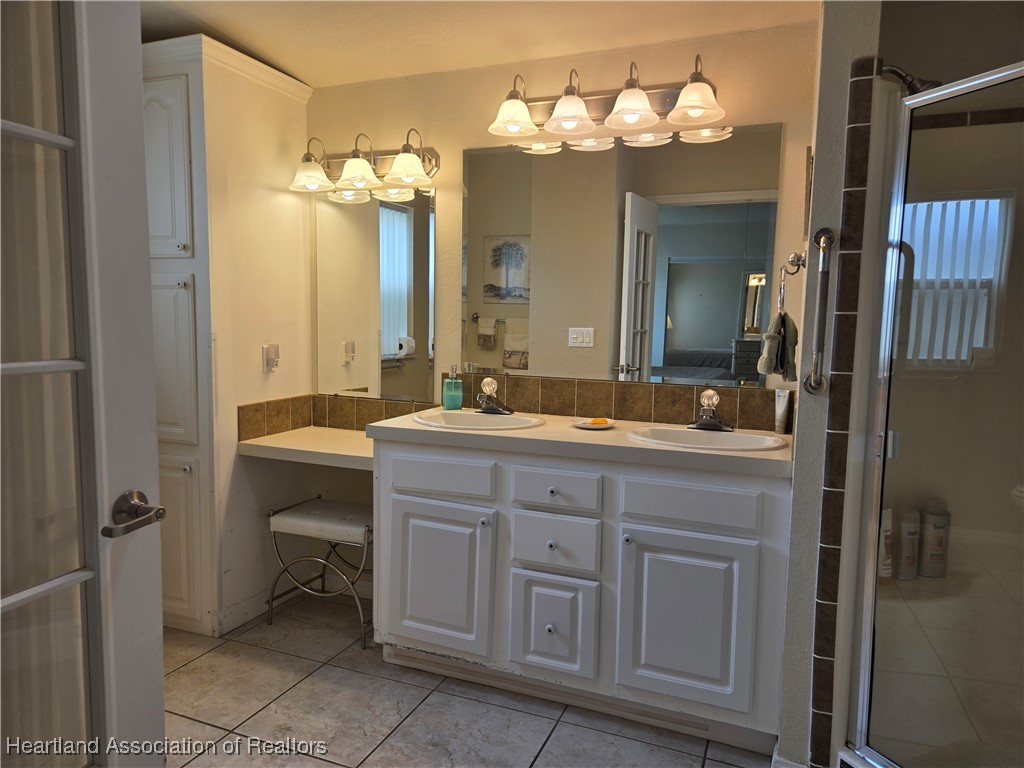3312 Beartooth Pass Sebring, FL 33872 - Photo 28 of 39 a bathroom with a double vanity sink and a mirror