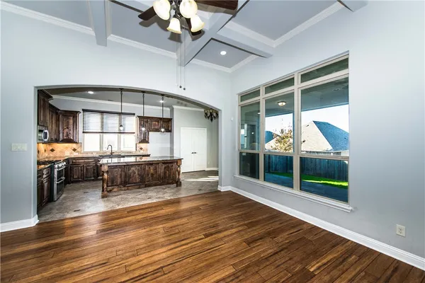 a view of a livingroom with a fireplace a ceiling fan and wooden floor
