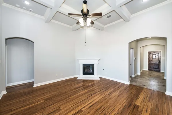 a view of a room with wooden floor ceiling fan and window