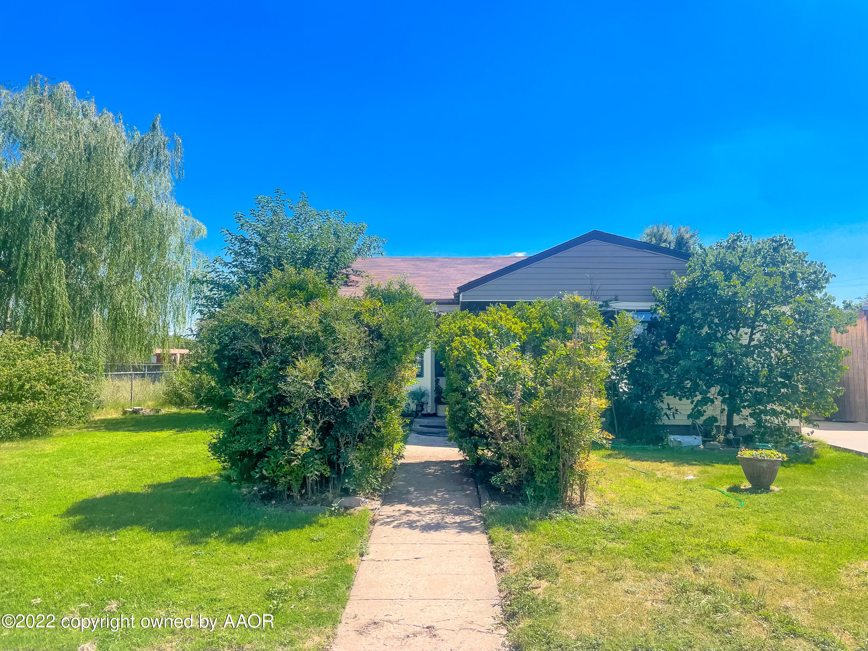1314 Coble Drive Borger, TX 79007 - Photo 2 of 16 a view of a yard with plants and a large tree