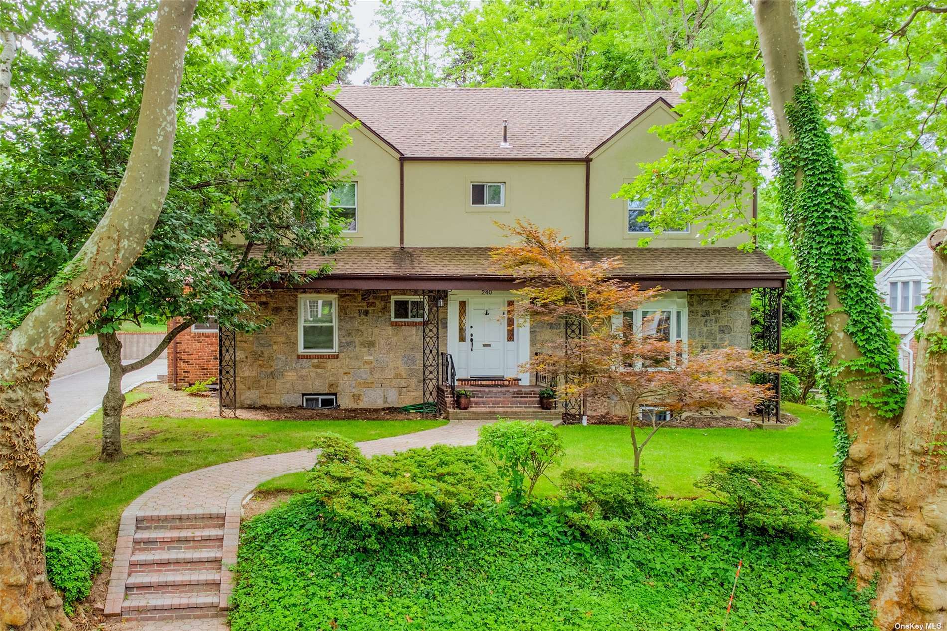 240 Clent Road Great Neck, NY 11021 - Photo 1 of 1 a front view of a house with a garden and trees