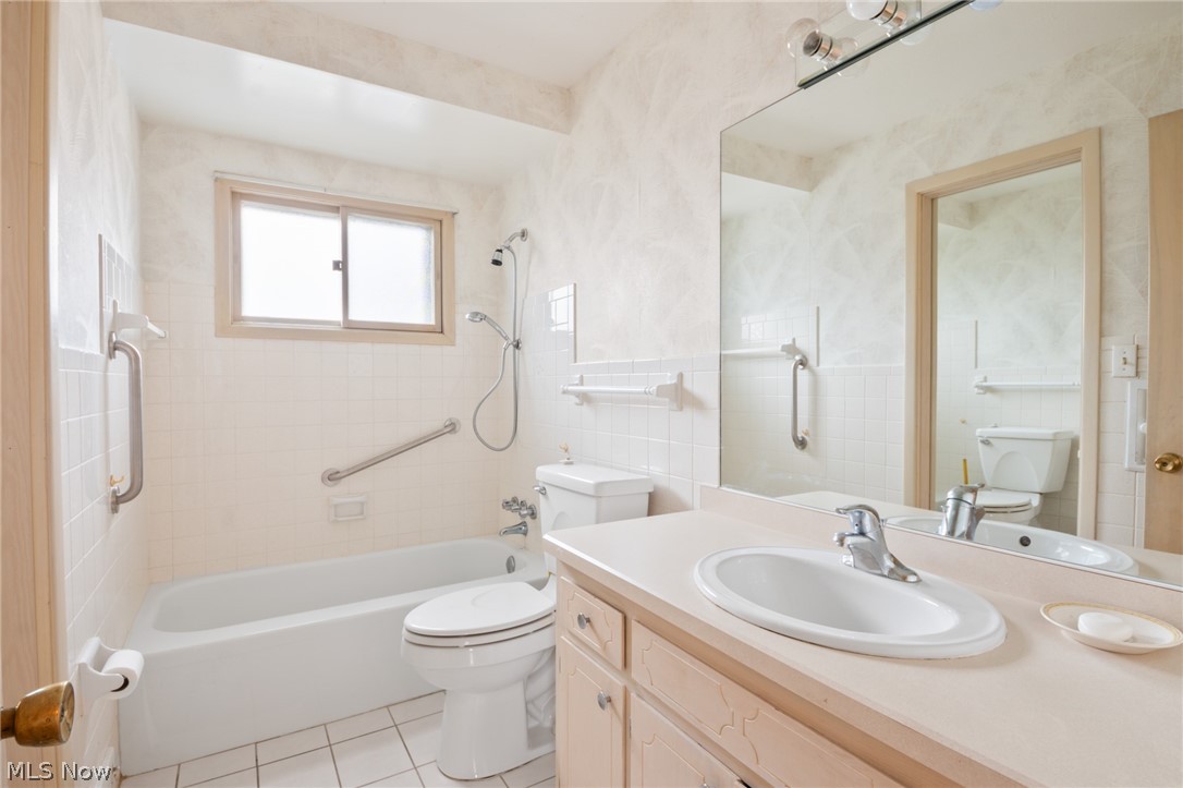 28879 Ridge Road Wickliffe, OH 44092 - Photo 15 of 34 Full bathroom with tiled shower / bath combo, toilet, tile floors, and vanity with extensive cabinet space