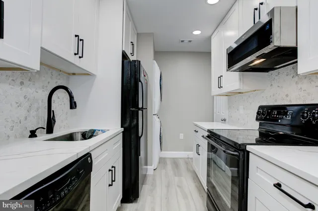 a kitchen with stainless steel appliances a sink stove and a refrigerator