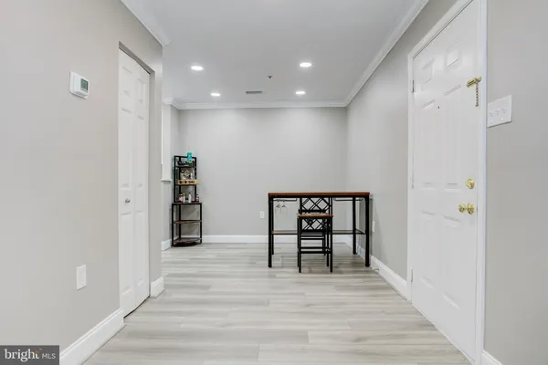 a view of a hallway with wooden floor and furniture