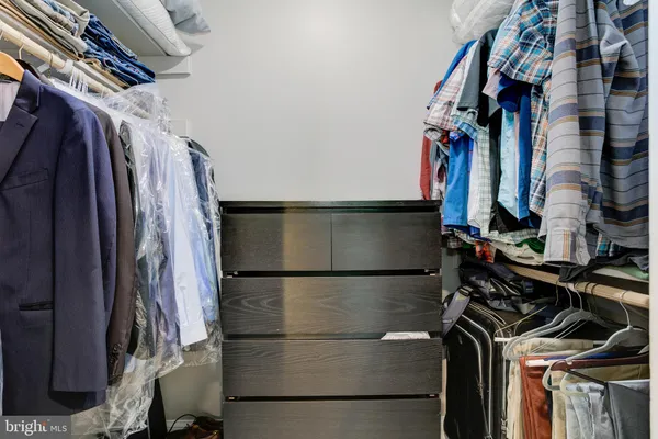 a view of walk in closet with clothes