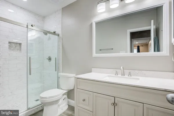 a bathroom with a sink a toilet and shower