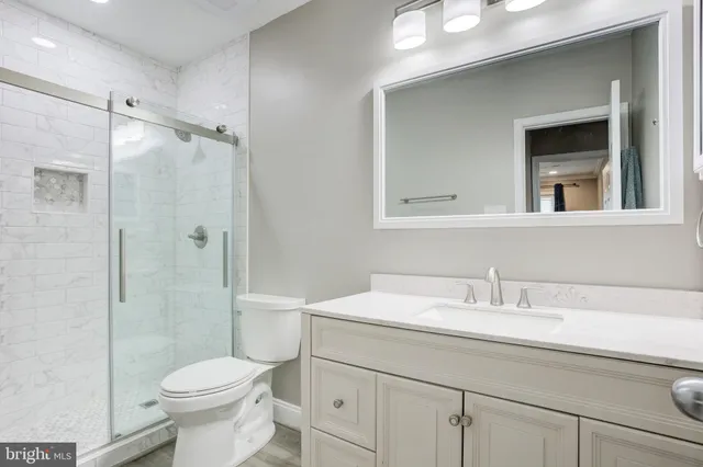 a bathroom with a sink a toilet and shower