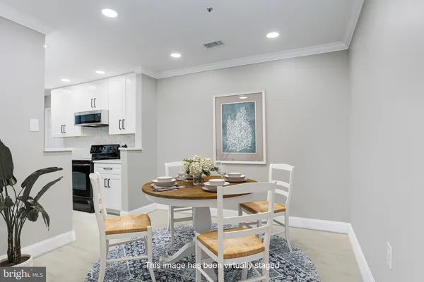 a kitchen with stainless steel appliances kitchen island granite countertop a sink a stove a dining table and chairs with wooden floor