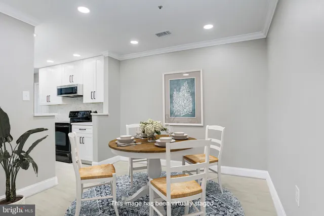 a kitchen with stainless steel appliances kitchen island granite countertop a sink a stove a dining table and chairs with wooden floor