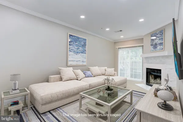 a living room with furniture a fireplace and a large window