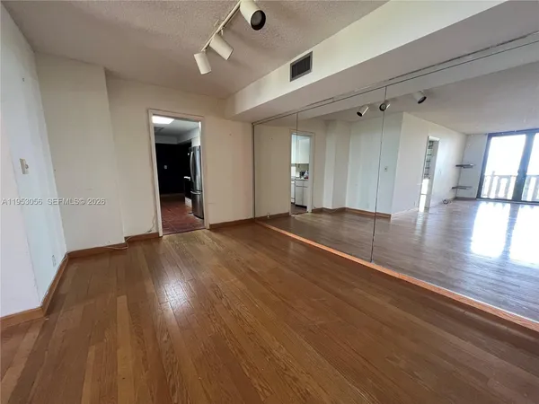 a view of an empty room with wooden floor