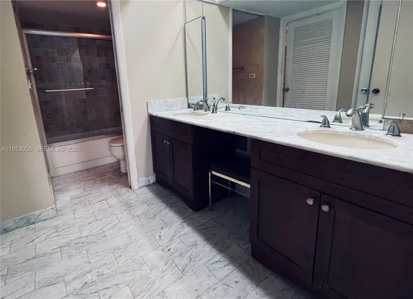 a bathroom with a double vanity sink a toilet and mirror