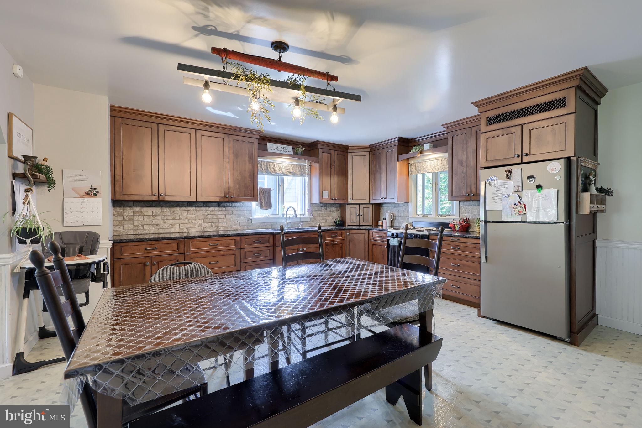 480 Jacobs Road Narvon, PA 17555 - Photo 20 of 90 a kitchen with stainless steel appliances granite countertop a dining table chairs refrigerator and cabinets
