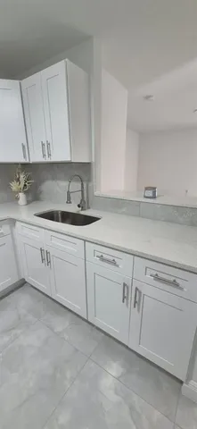 a kitchen with white cabinets white appliances sink and dishwasher