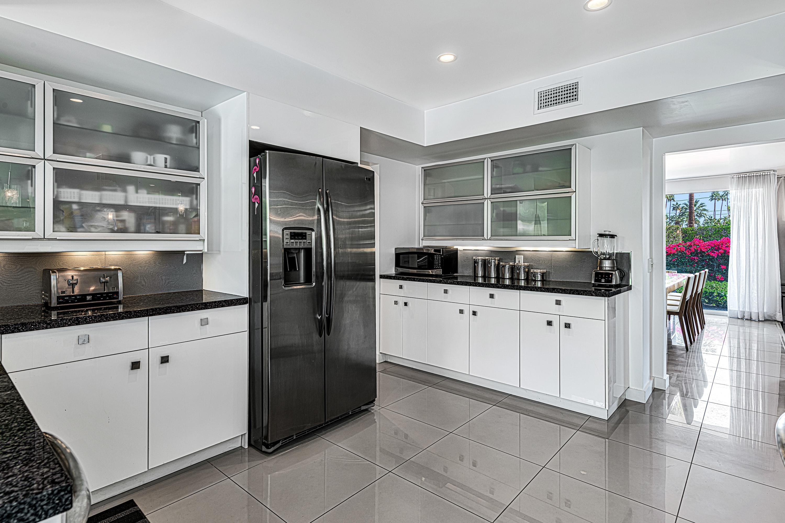 1130 East Deepwell Road Palm Springs, CA 92264 - Photo 8 of 55 a kitchen with stainless steel appliances granite countertop a refrigerator and a sink