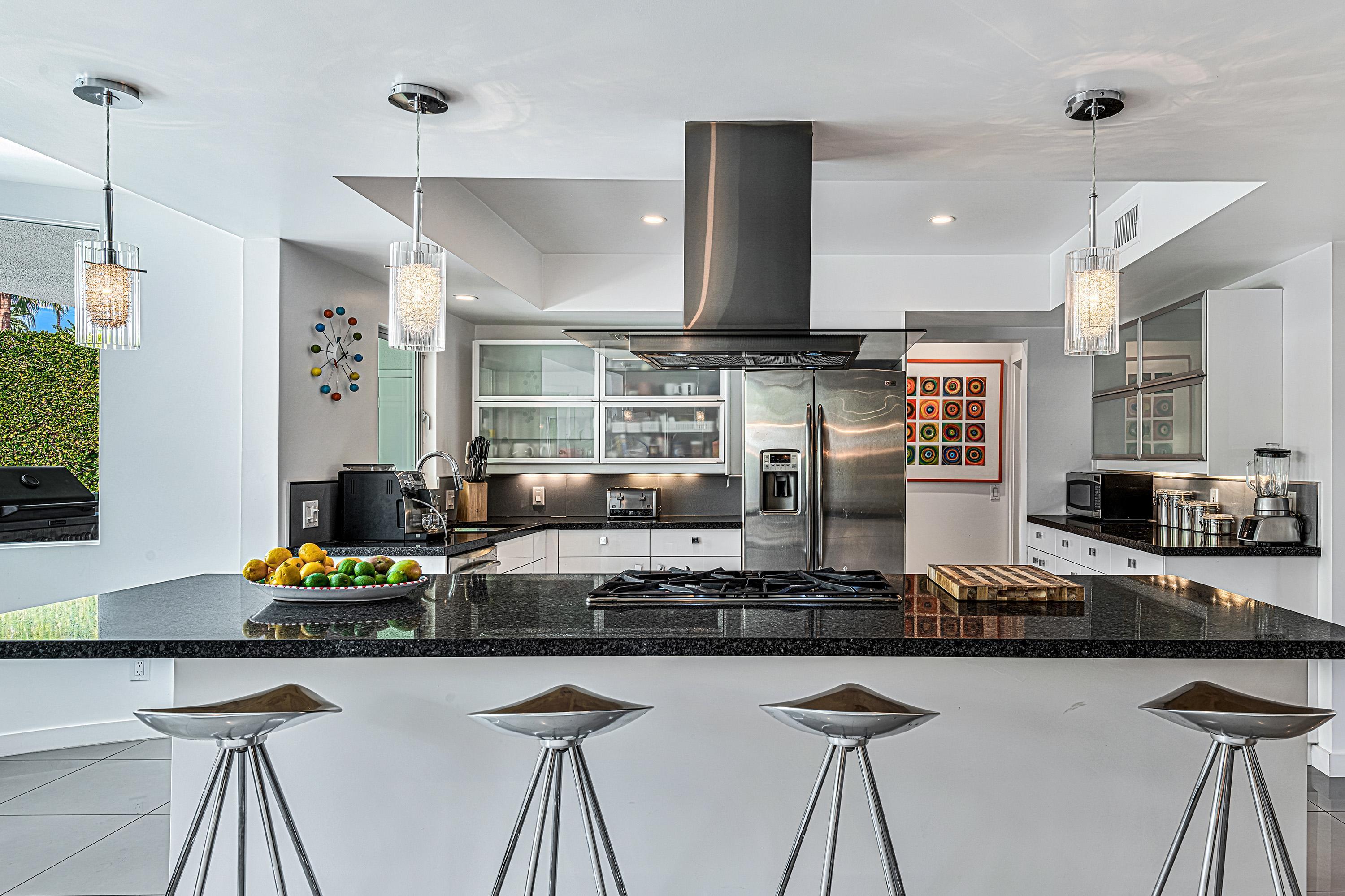 1130 East Deepwell Road Palm Springs, CA 92264 - Photo 9 of 55 a kitchen with stainless steel appliances kitchen island granite countertop a stove and cabinets