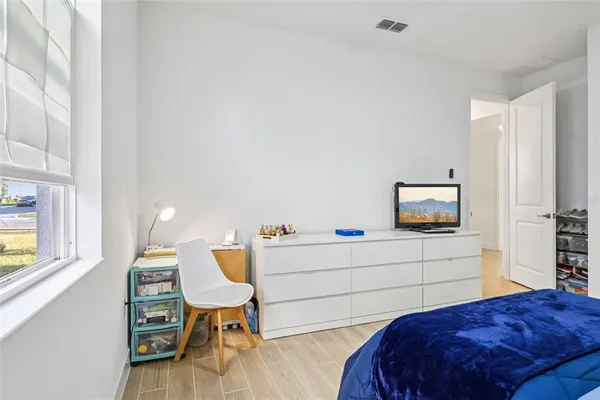 a bedroom with a bed and wooden floor