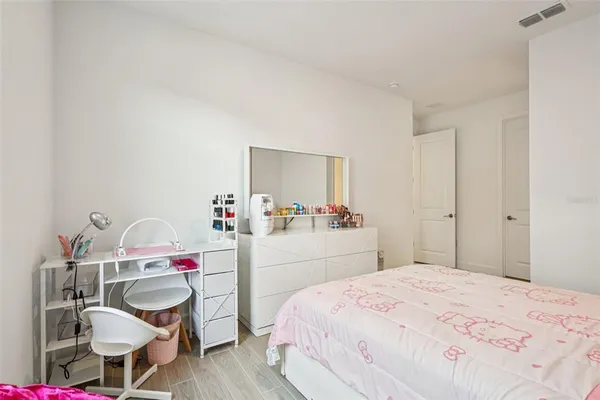 a bedroom with a large bed a chandelier and window