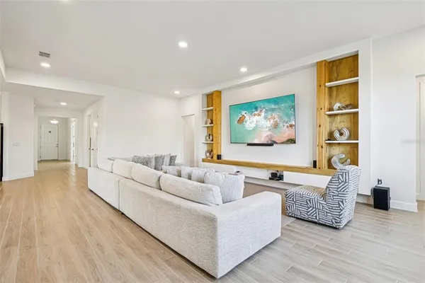 a living room with kitchen island furniture and a flat screen tv