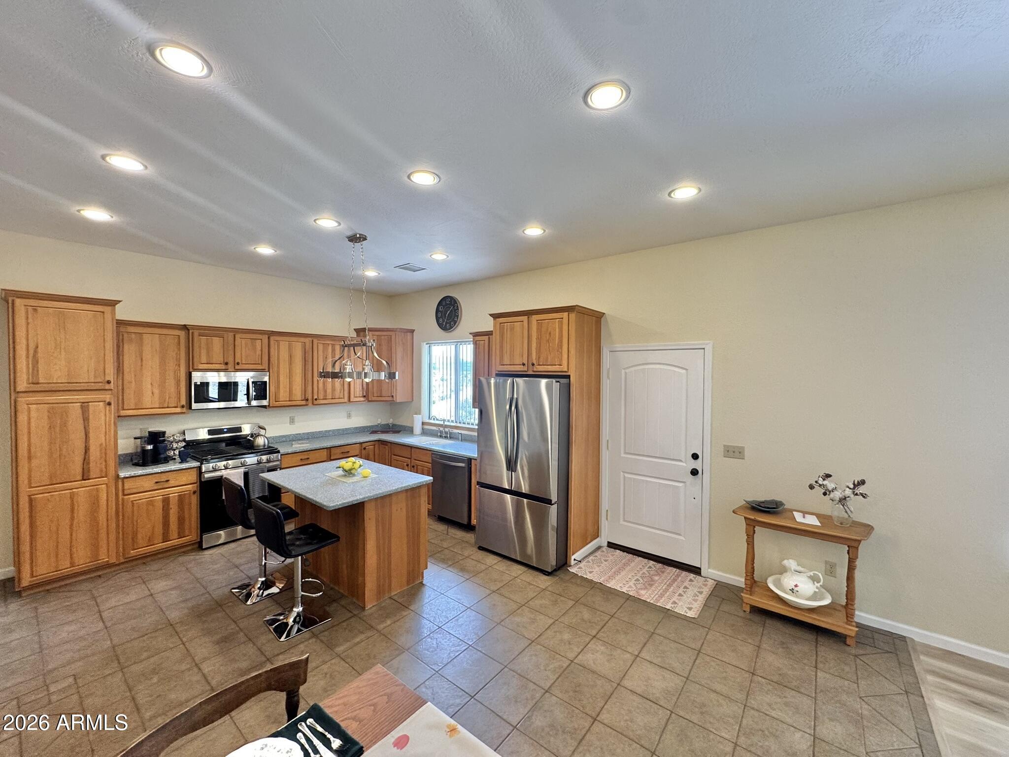 18168 Spoon Road Kirkland, AZ 86332 - Photo 18 of 59 a view of a kitchen with refrigerator and dining table