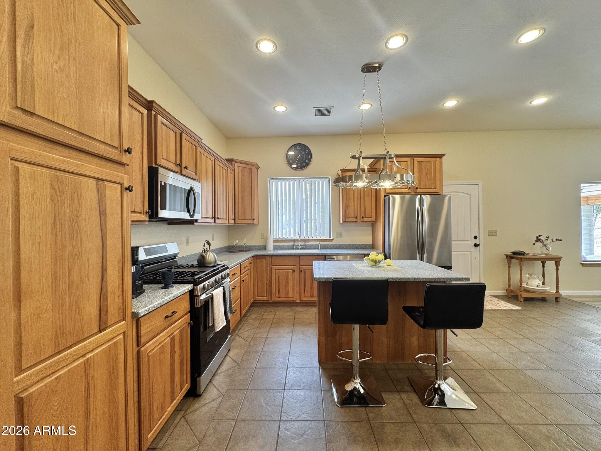 18168 Spoon Road Kirkland, AZ 86332 - Photo 20 of 59 a kitchen with stainless steel appliances granite countertop sink stove refrigerator and cabinets