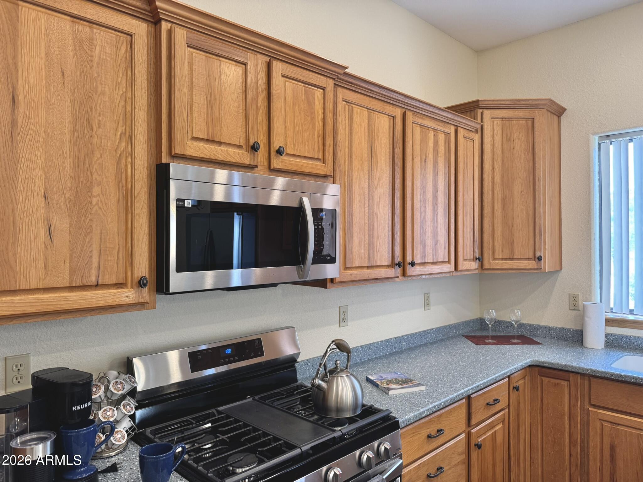 18168 Spoon Road Kirkland, AZ 86332 - Photo 22 of 59 a kitchen with granite countertop a stove sink and cabinets