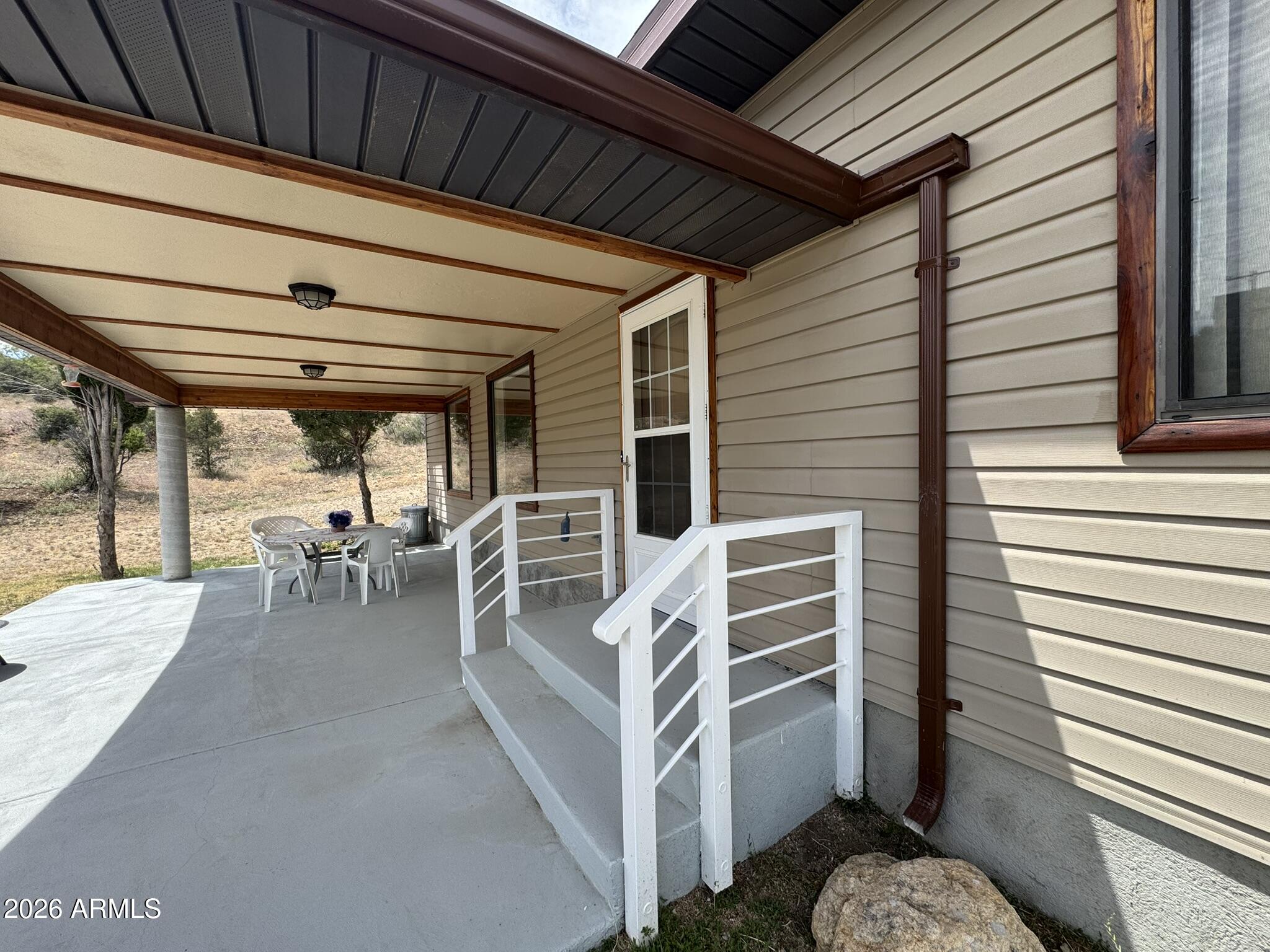 18168 Spoon Road Kirkland, AZ 86332 - Photo 5 of 59 a view of a patio with table and chairs and wooden floor