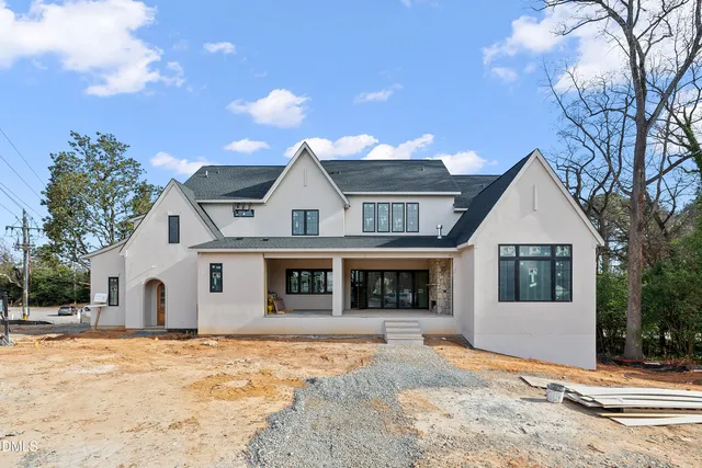 a view of a white house with a yard and large tree