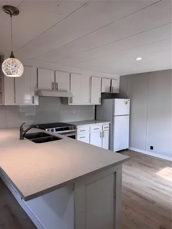 a kitchen with stainless steel appliances granite countertop a sink a stove a refrigerator and cabinets