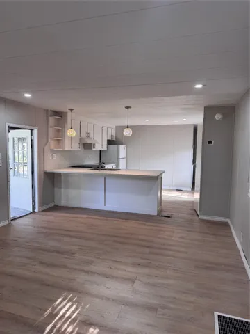 a view of a kitchen with a sink and a refrigerator