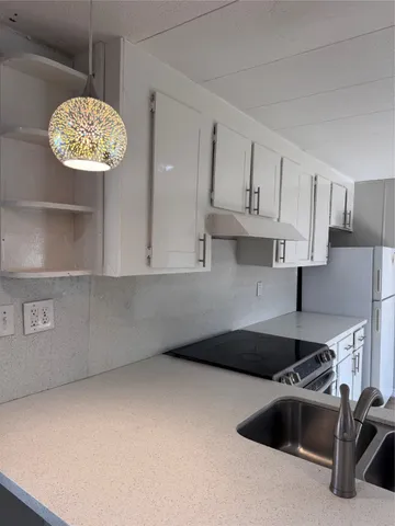 a kitchen with kitchen island a sink a stove and refrigerator