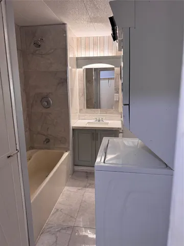 a bathroom with a sink a bathtub and a window