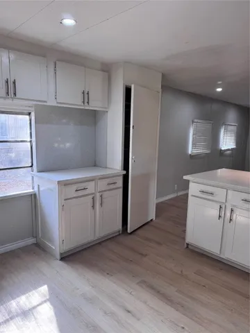 a kitchen with white cabinets and sink