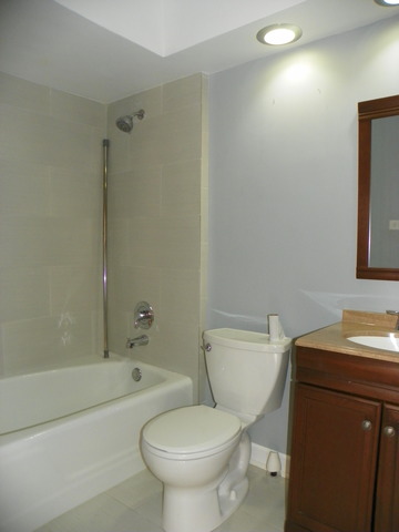 10108 South Pulaski Road, Unit 1S Oak Lawn, IL 60453 - Photo 7 of 8 a white toilet sitting next to a bath tub