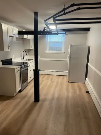a kitchen with a wooden floor and a stove top oven