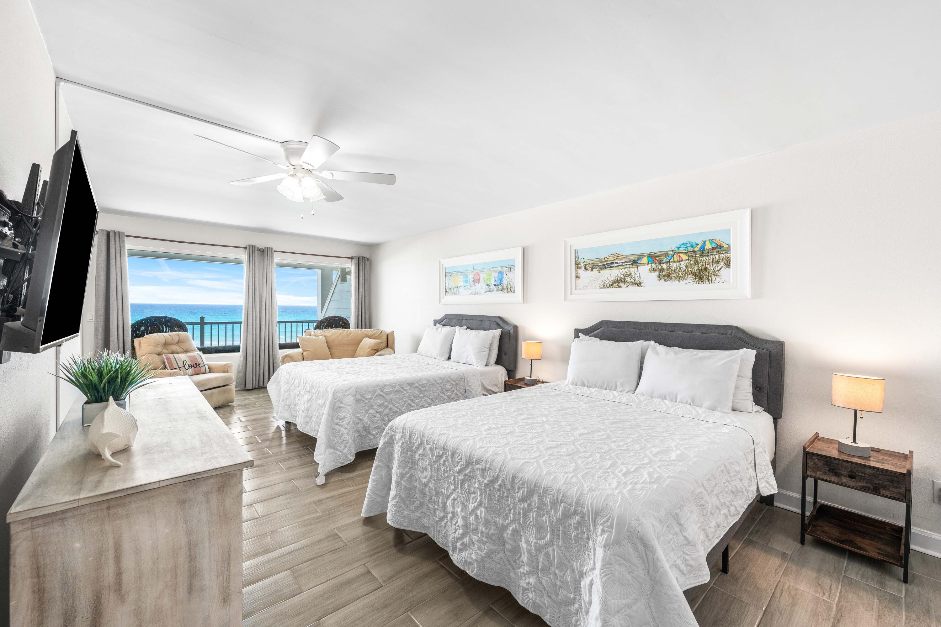 22519 Front Beach Road, Unit 108 Panama City Beach, FL 32413 - Photo 12 of 38 a spacious bedroom with two beds and a chandelier