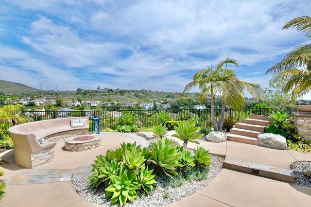 a view of a patio with a table and chairs under an umbrella