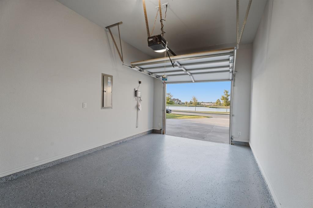 1316 Limestone Ridge Road Mansfield, TX 76063 - Photo 38 of 40 Spacious garage with an epoxy-coated flooring, white textured walls, and an automatic garage door opener