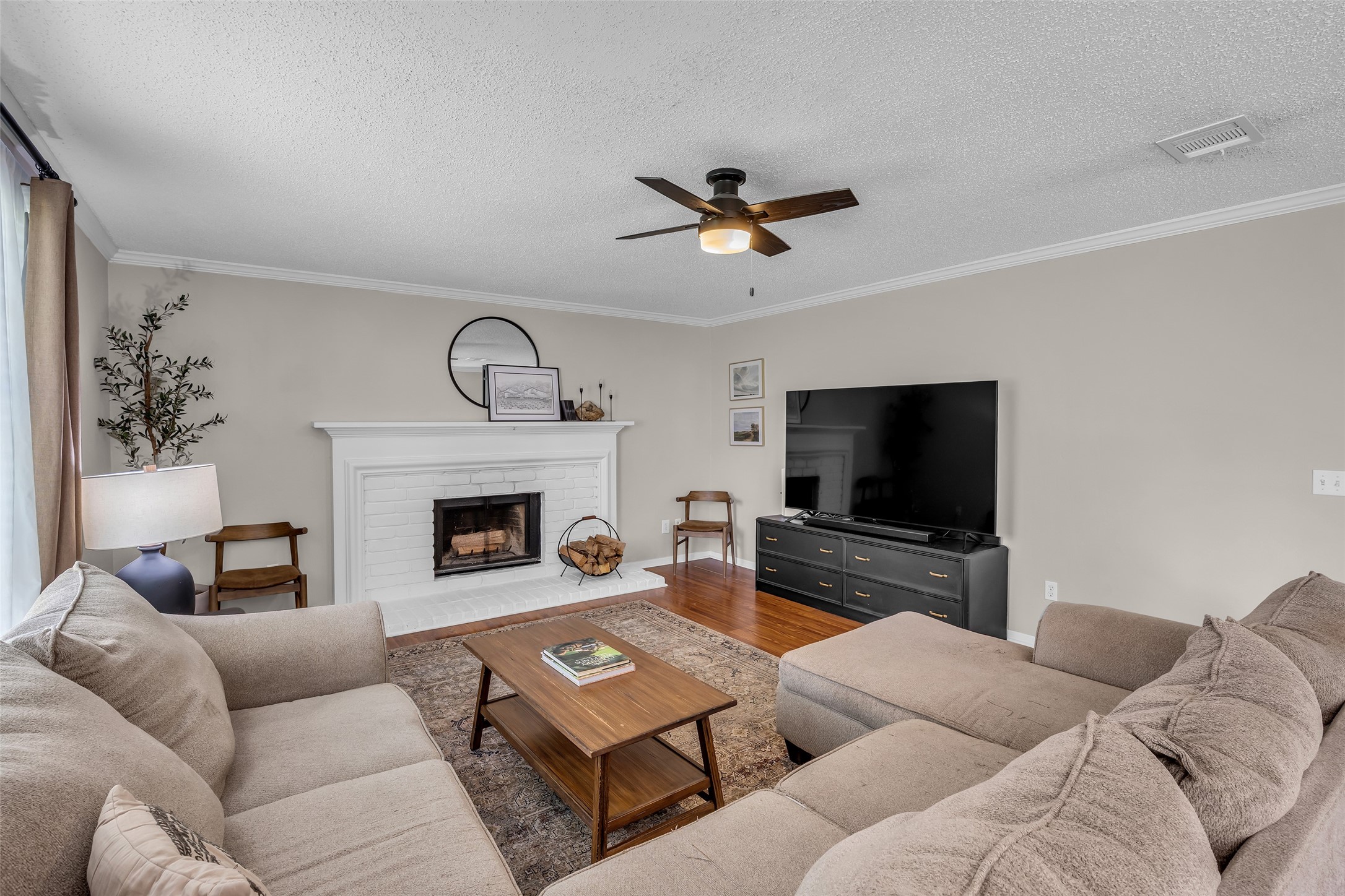 9415 Towerstone Drive Spring, TX 77379 - Photo 25 of 41 This spacious bedroom features a cozy bed with wooden furniture, a ceiling fan, and a desk area for work. Large windows provide ample natural light, and the room is tastefully decorated with neutral tones and greenery.