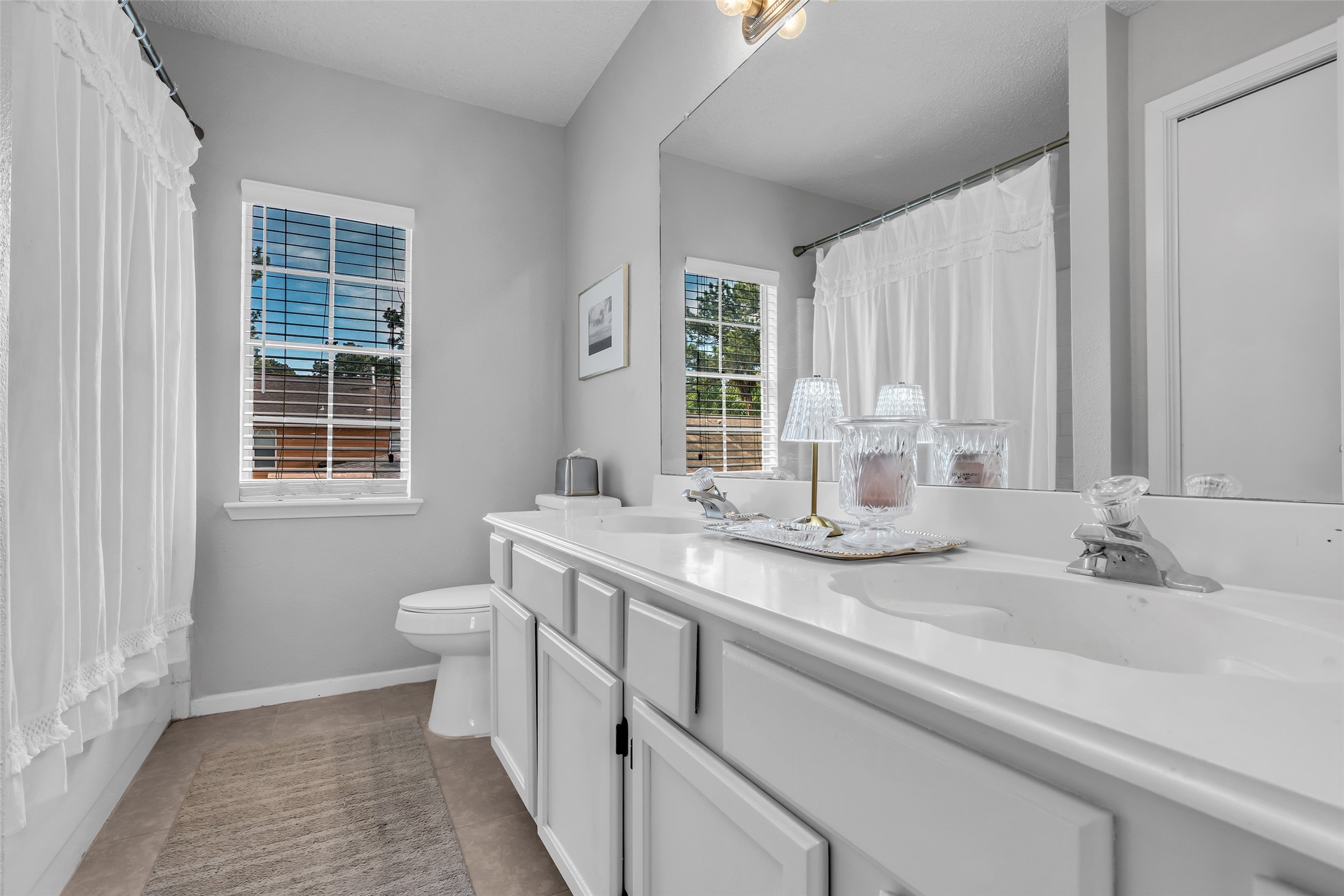 9415 Towerstone Drive Spring, TX 77379 - Photo 32 of 41 This spacious backyard features a well-maintained lawn, a wooden playset for children, and a cozy patio area with flower planters, perfect for family gatherings and relaxation. The yard is enclosed by a wooden fence, offering privacy and safety.