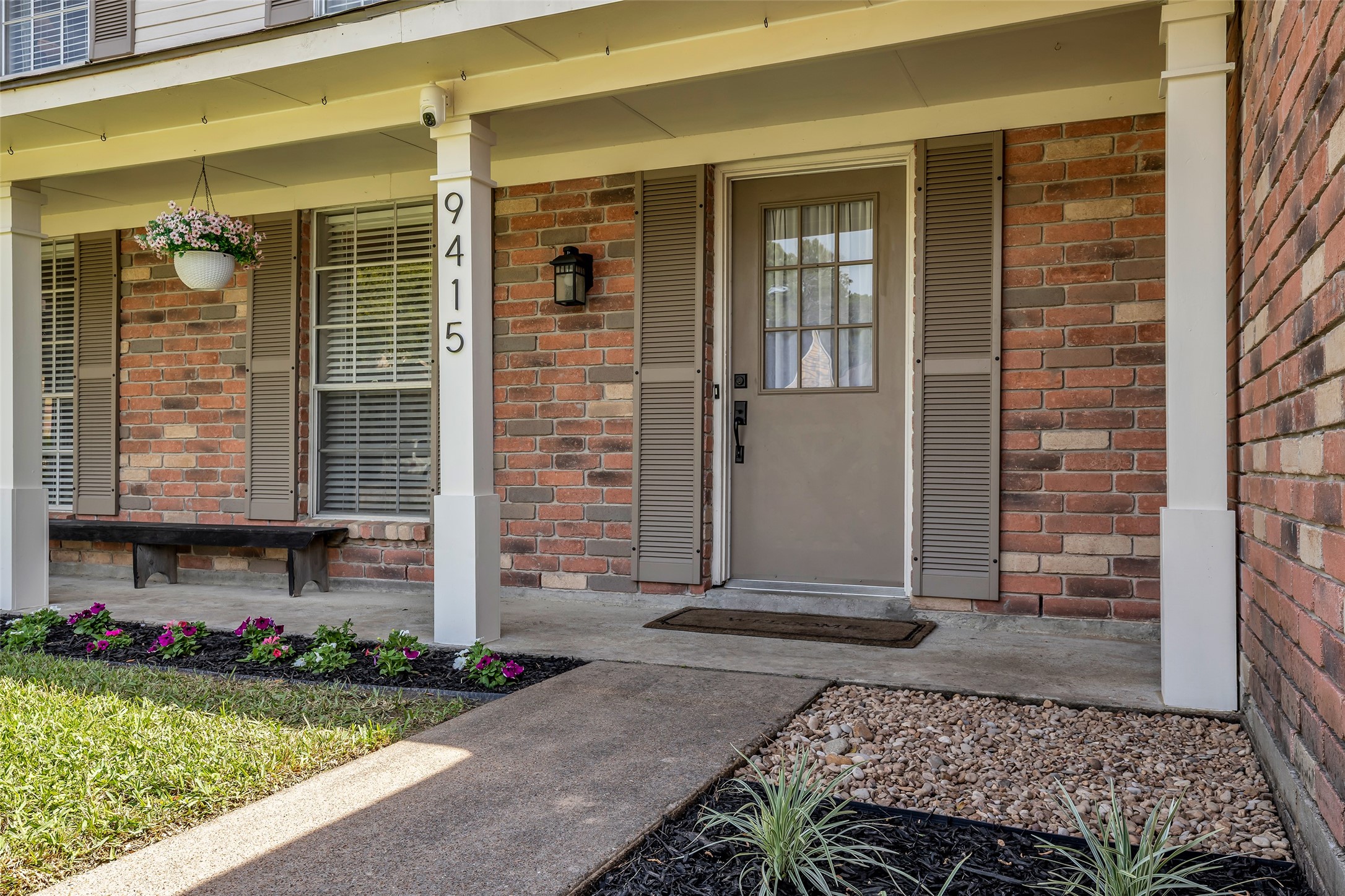 9415 Towerstone Drive Spring, TX 77379 - Photo 8 of 41 Charming two-story brick home with a spacious front lawn, large windows, and an attached two-car garage. The property features a welcoming front porch and is surrounded by mature trees, offering a serene suburban setting.