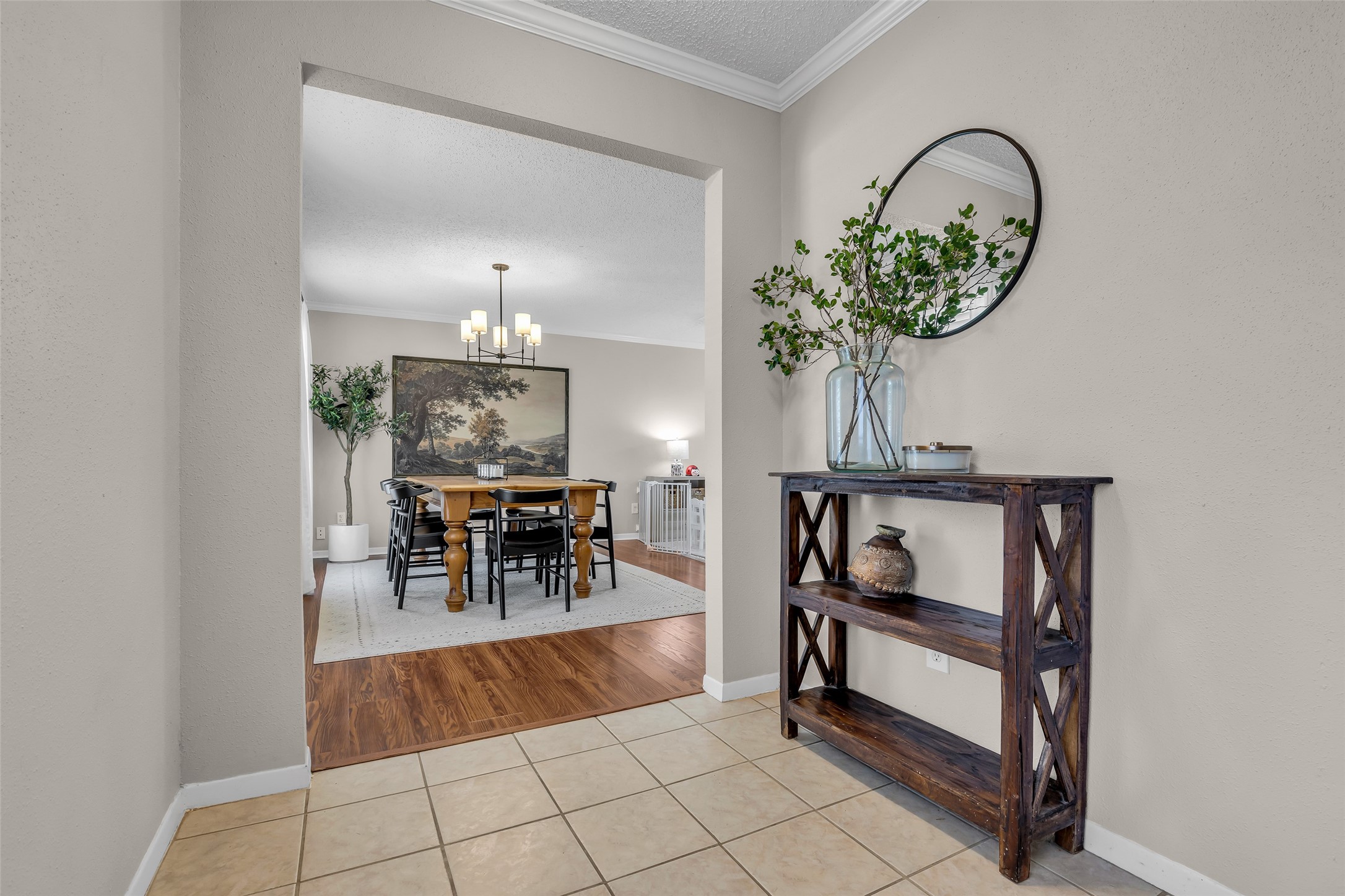 9415 Towerstone Drive Spring, TX 77379 - Photo 10 of 41 This inviting open-concept space features a dining area with a wooden table and modern chandelier, leading to a cozy living room. Light walls and ample natural light create a warm, welcoming atmosphere.