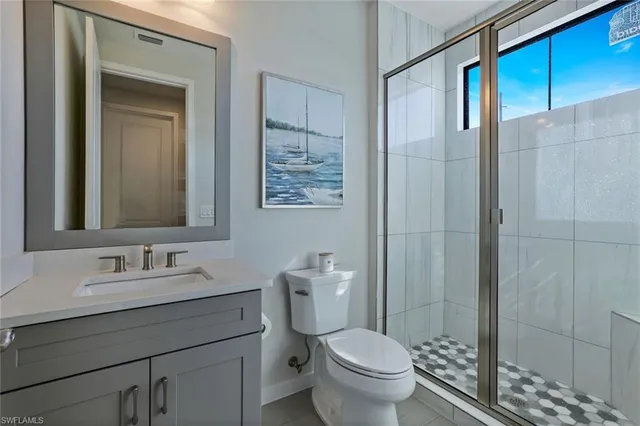 a bathroom with a granite countertop sink a toilet and shower