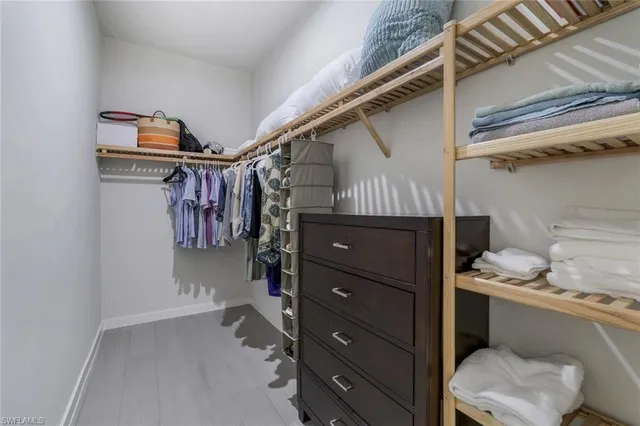 a view of walk in closet with clothes and shoes