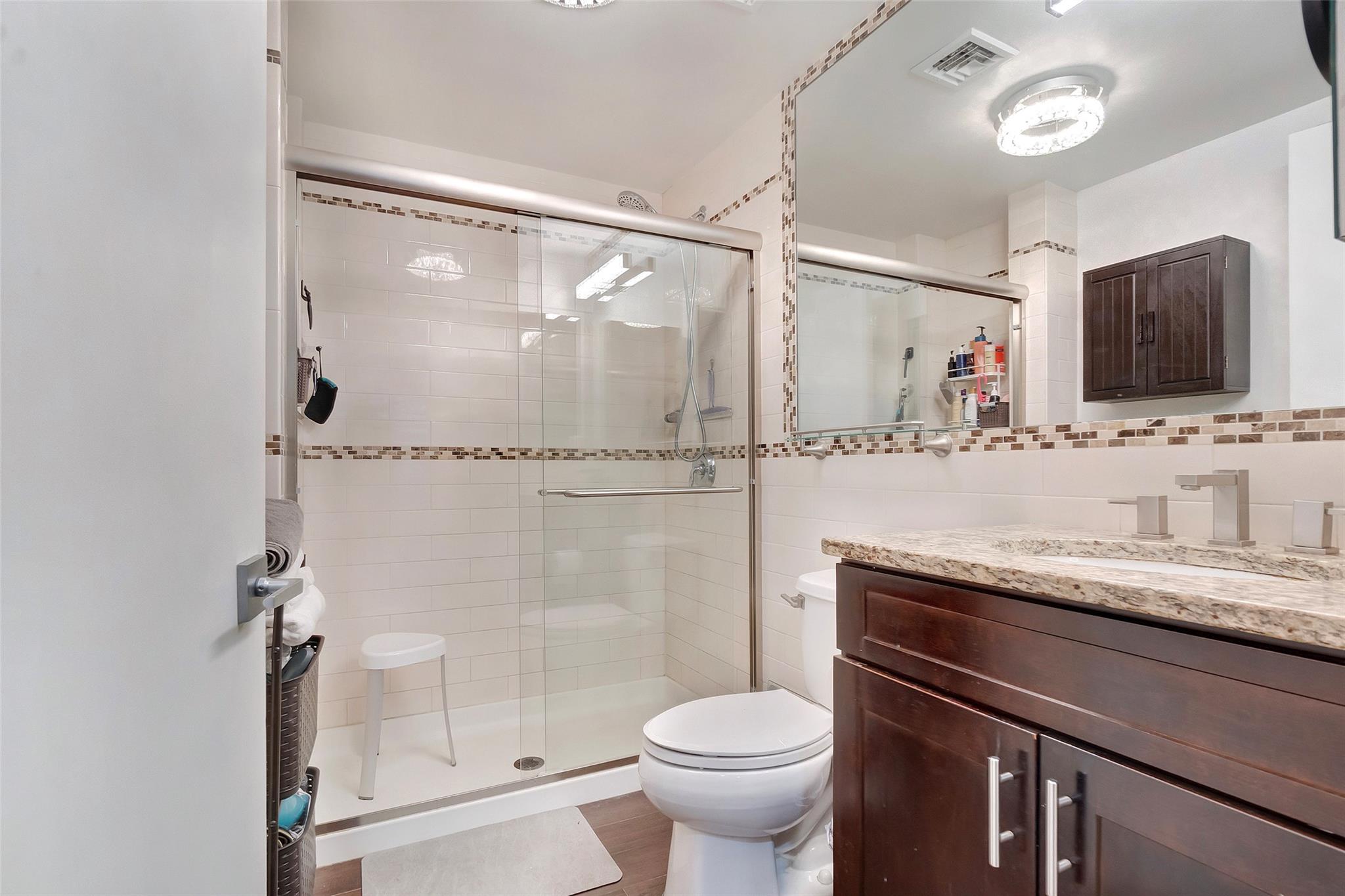 151 Beach 96th Street, Unit 5D Queens, NY 11693 - Photo 14 of 18 Bathroom featuring toilet, vanity, backsplash, a shower stall, and visible vents
