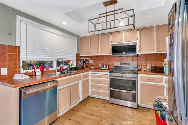 a kitchen with stainless steel appliances granite countertop a stove refrigerator sink and cabinets